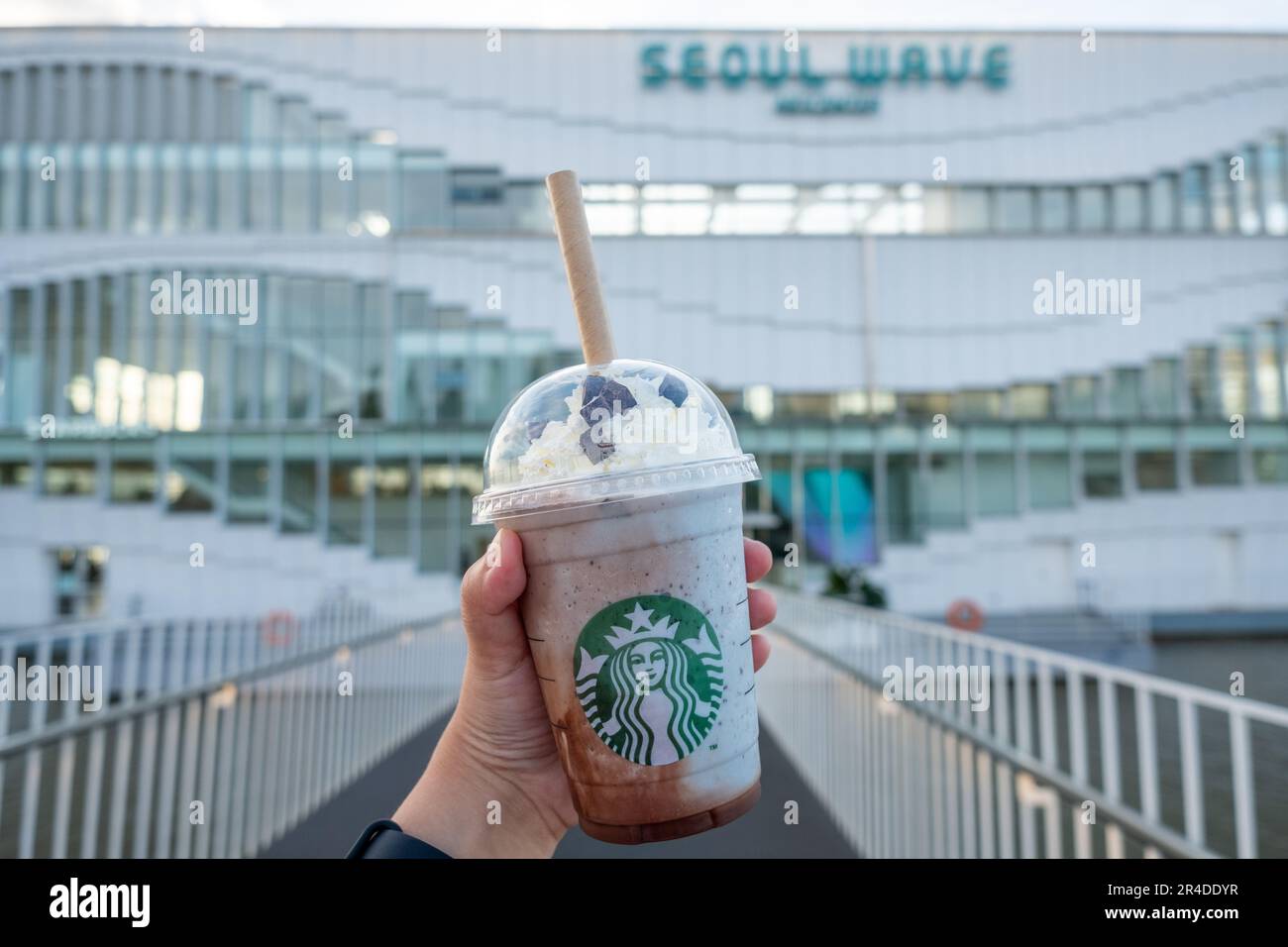 Seoul, Südkorea - 14. Juli 2022: Handgehaltener Becher Minzschokolade CIP, gemischt vor dem Seoul Wave Art Center Gebäude, schwimmendes Starbucks auf Ha Stockfoto
