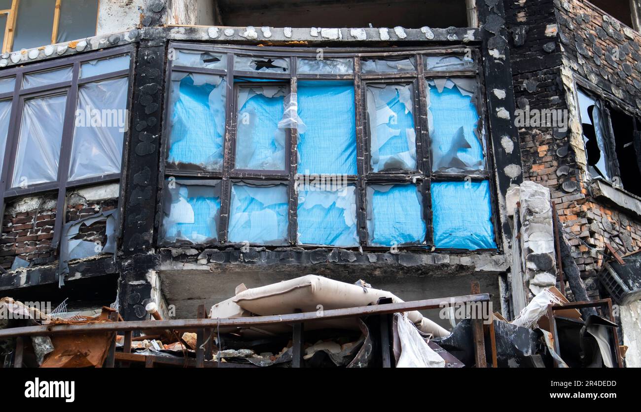 Fenster des Hauses mit zerbrochenem Glas. Selektiver Fokus. Die Fenster im Apartmentgebäude wurden durch die Explosion und die Muschelsplitter beschädigt Stockfoto