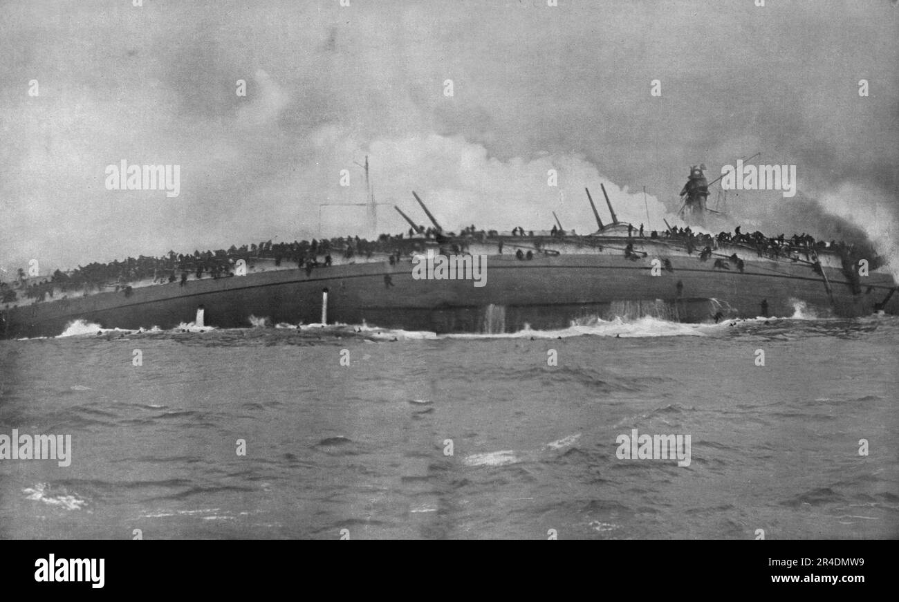 "Les derniers instants du "Blucher"; Cette Photography, unique dans les annales de la guerre navale, fut priseau Moment Precis ou le croiseur allemand tournait sur lui-meme en s'enfoncant tandis que son equipage se jetait glissait a la mer", 1915 (1924). Aus „L'Album de la Guerre 1914-1919, Volume I“ [L'Illustration, Paris, 1924]. Stockfoto