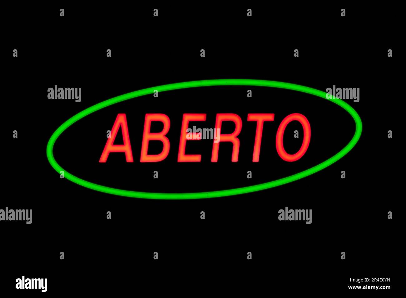 Ein grüner ovaler Neon mit einem weiteren roten Neon im Inneren, geformt im portugiesischen Wort „Aberto“, was auf Spanisch „Open“ bedeutet. Stockfoto