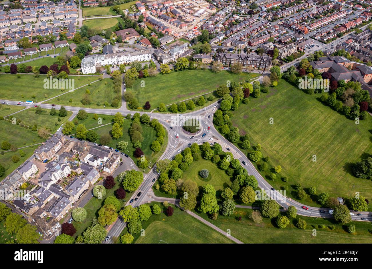 Blick aus der Vogelperspektive direkt über einem Kreisverkehr in Harrogate, North Yorkshire, mit von Bäumen gesäumten Straßen und bewegendem Verkehr Stockfoto