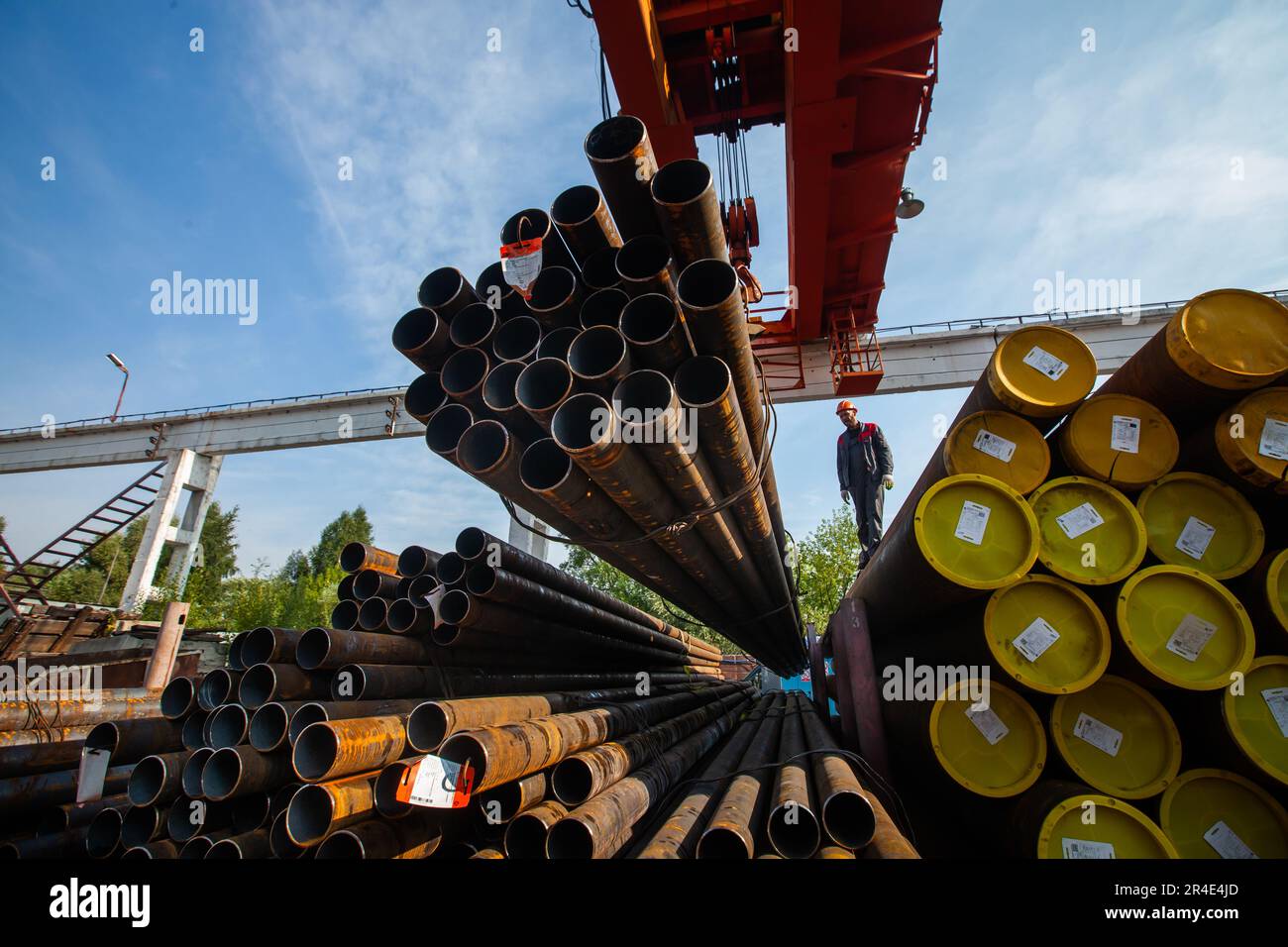 Podolsk, Provinz Moskau - 02. August 2021: Rohrlager. Arbeiter beladen Rohre mit Brückenkran Stockfoto