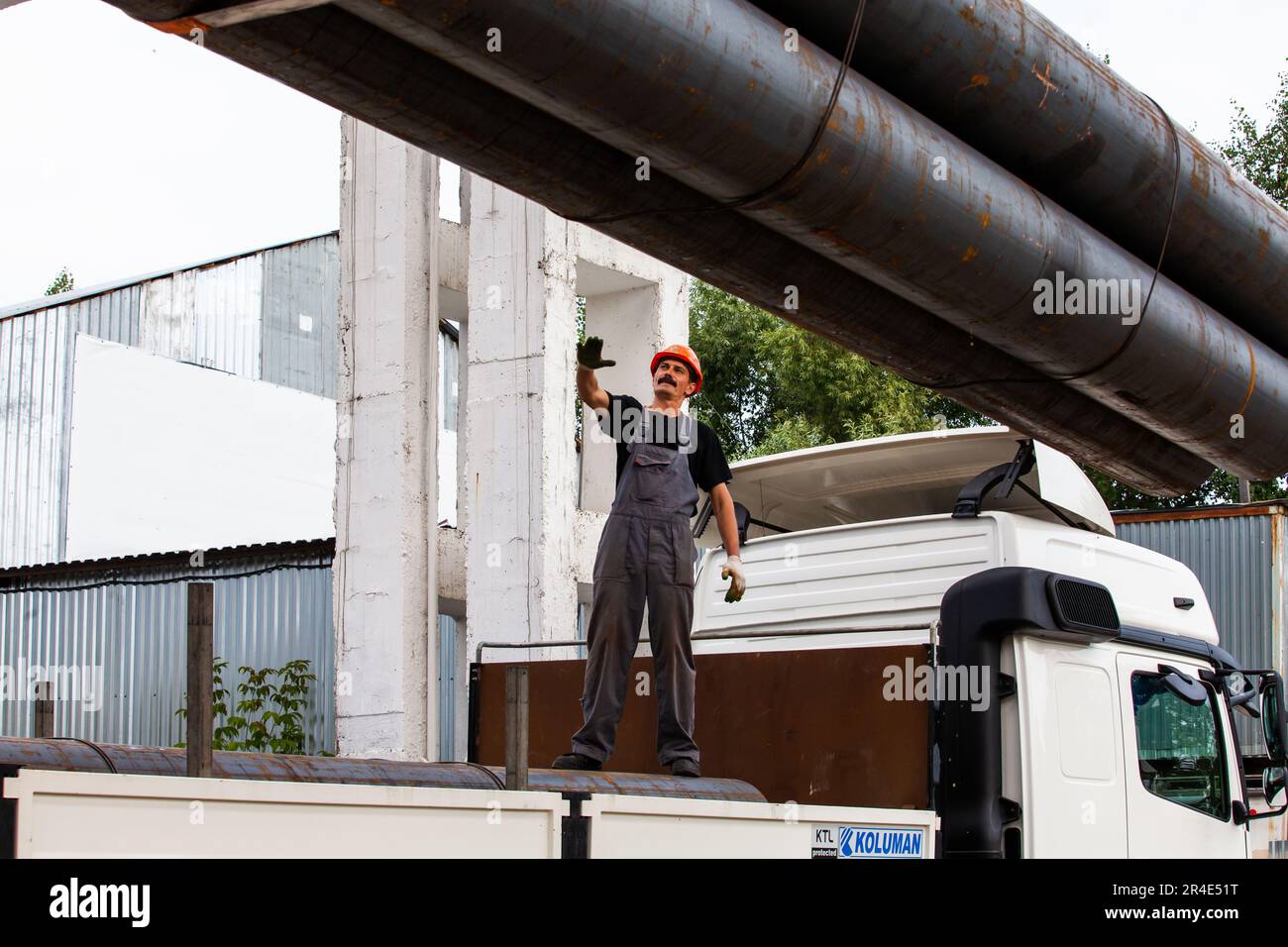 Podolsk, Provinz Moskau - 02. August 2021: Rohrlager. Arbeiter lädt Stahlrohre auf den Lkw Stockfoto