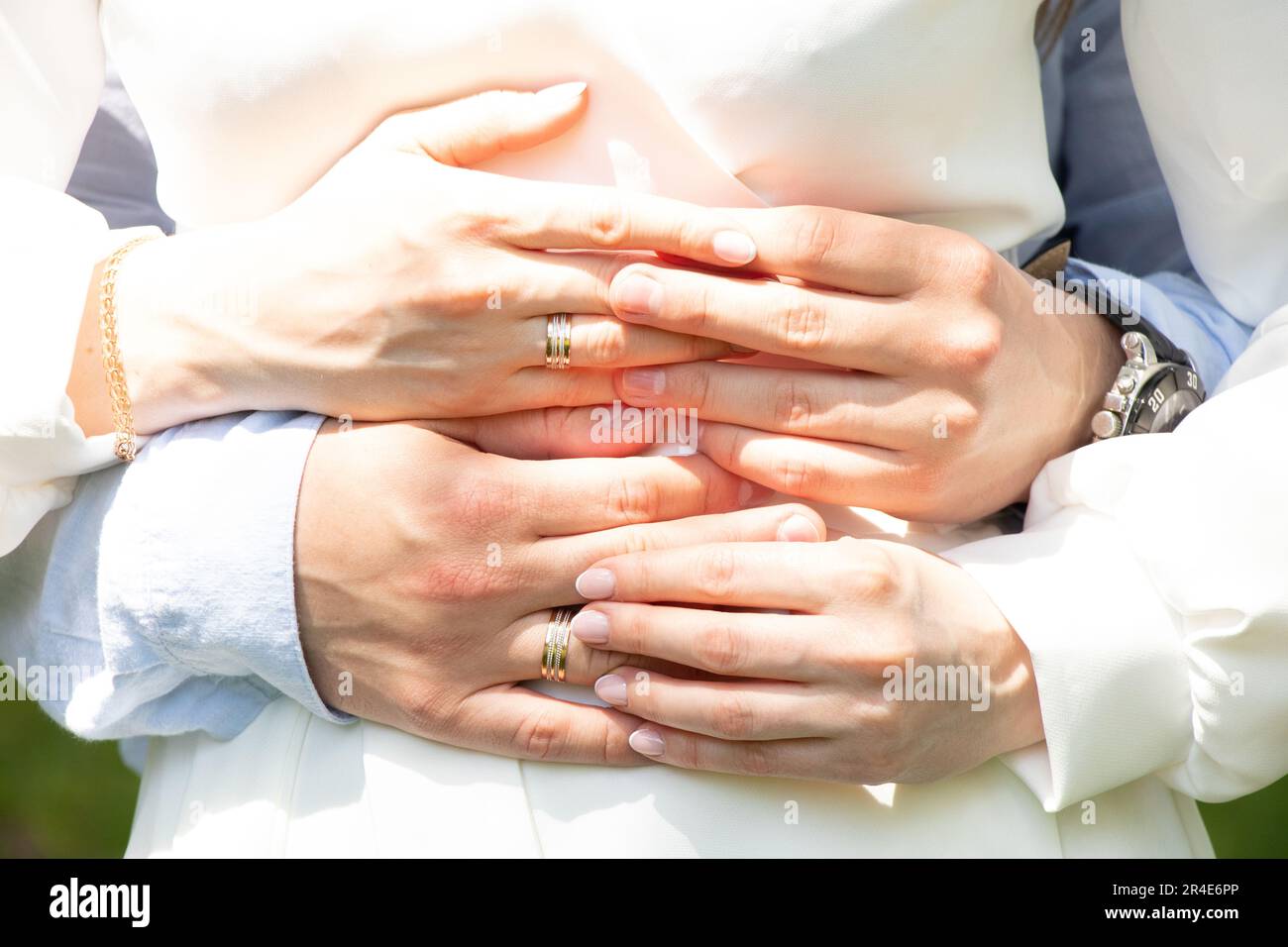 Die Hände der Frischvermählten mit Ringen am Hochzeitstag halten sich gegenseitig, Hochzeit Stockfoto