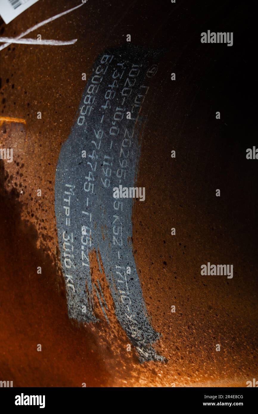 Markierung des Stahlrohrs. Nahaufnahme von Zahlen und Buchstaben auf rostem Metall Stockfoto