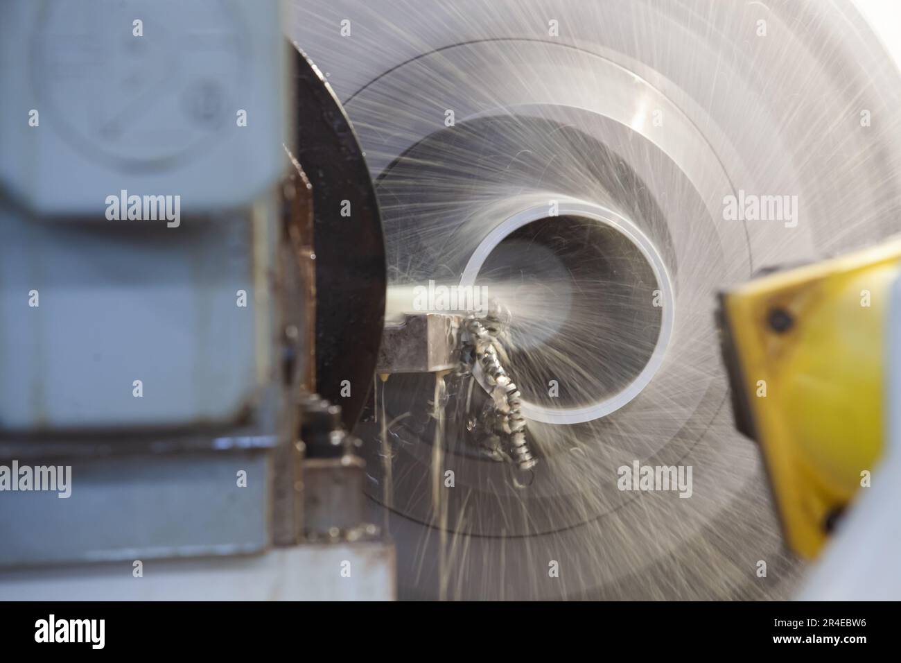 Bearbeitungsrohr auf Drehmaschine. Nahaufnahme. Wasserkühlung des Werkzeugs. Stahlspäne (Späne). Stockfoto