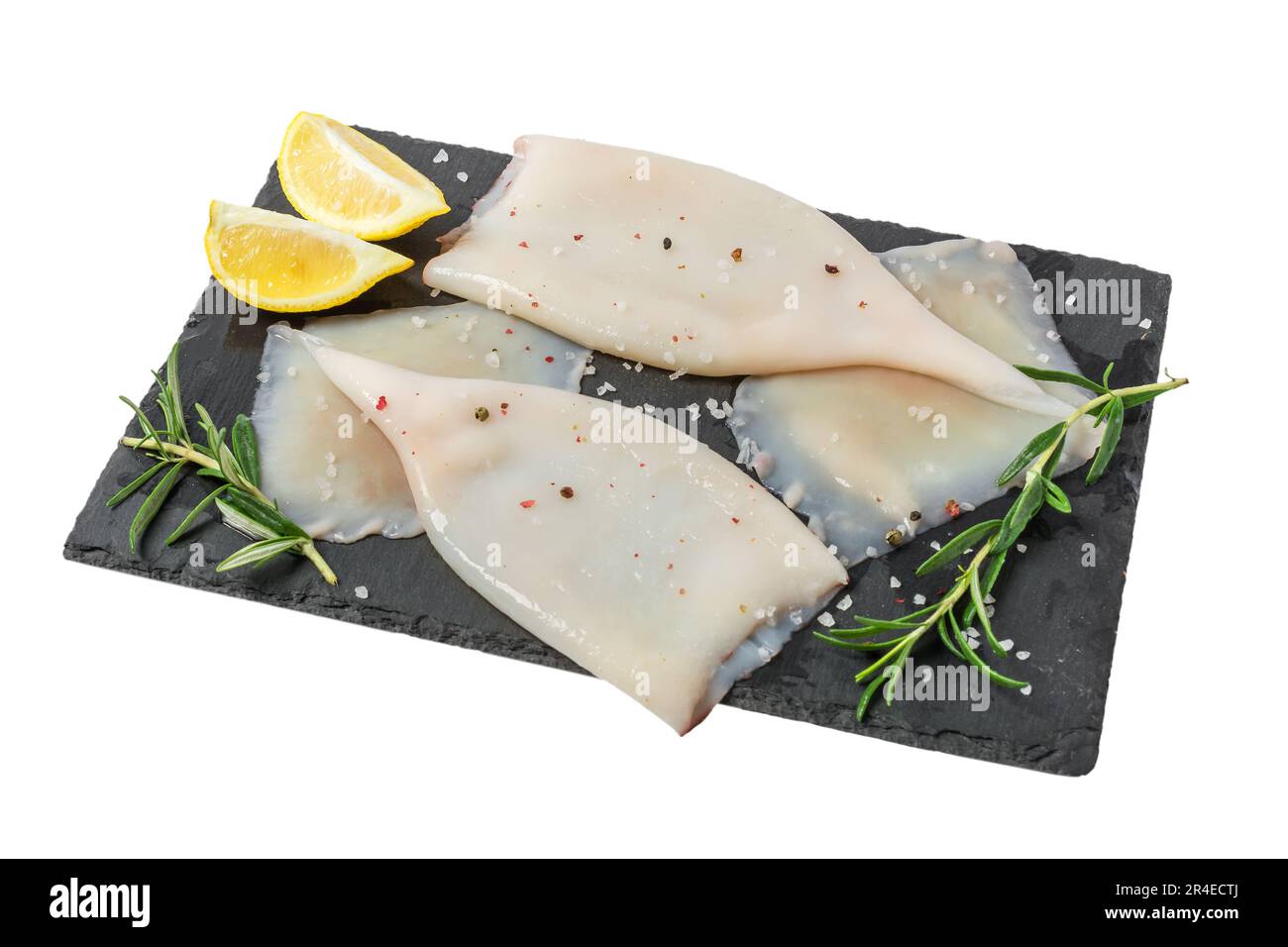 Frisches rohes Tintenfischfilet mit Zutaten zum Kochen auf blak Schieferbrett isoliert Stockfoto