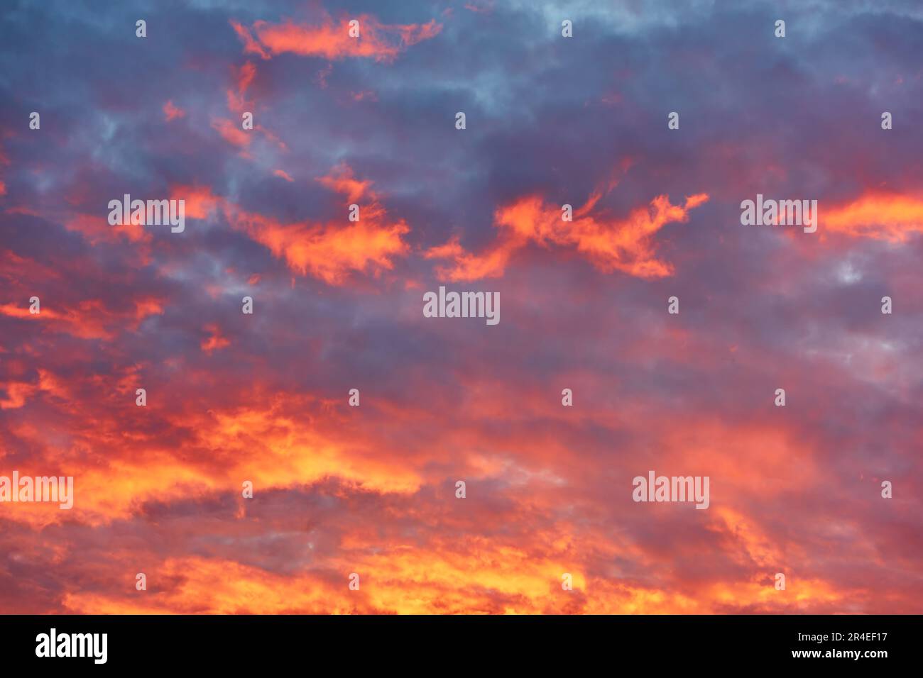 Wunderschöner Himmel mit dramatischen rot-orangefarbenen Wolken bei Sonnenuntergang. Abstrakter Hintergrund mit Kopierbereich Stockfoto