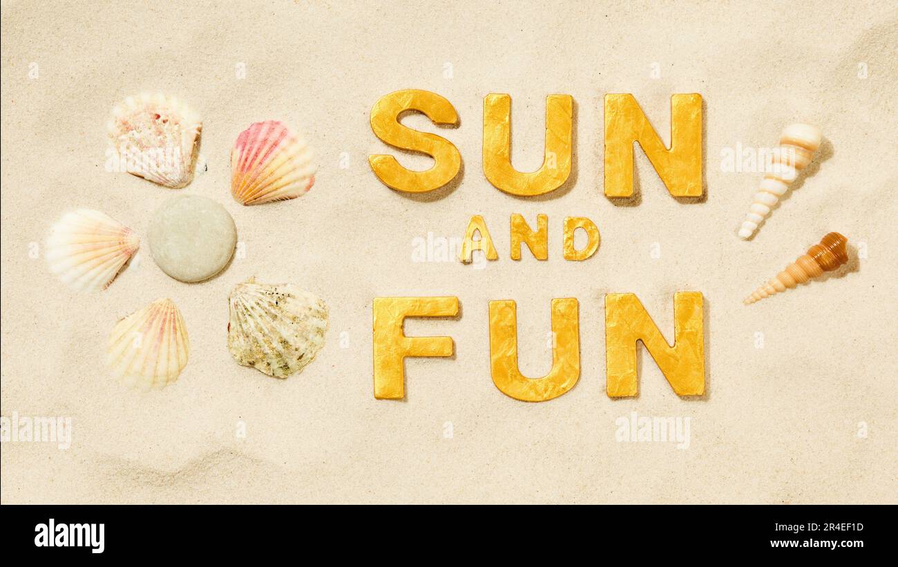 Sonne und Spaß - Text in weißem Sandstrand mit Sonnensymbol von Muscheln Stockfoto
