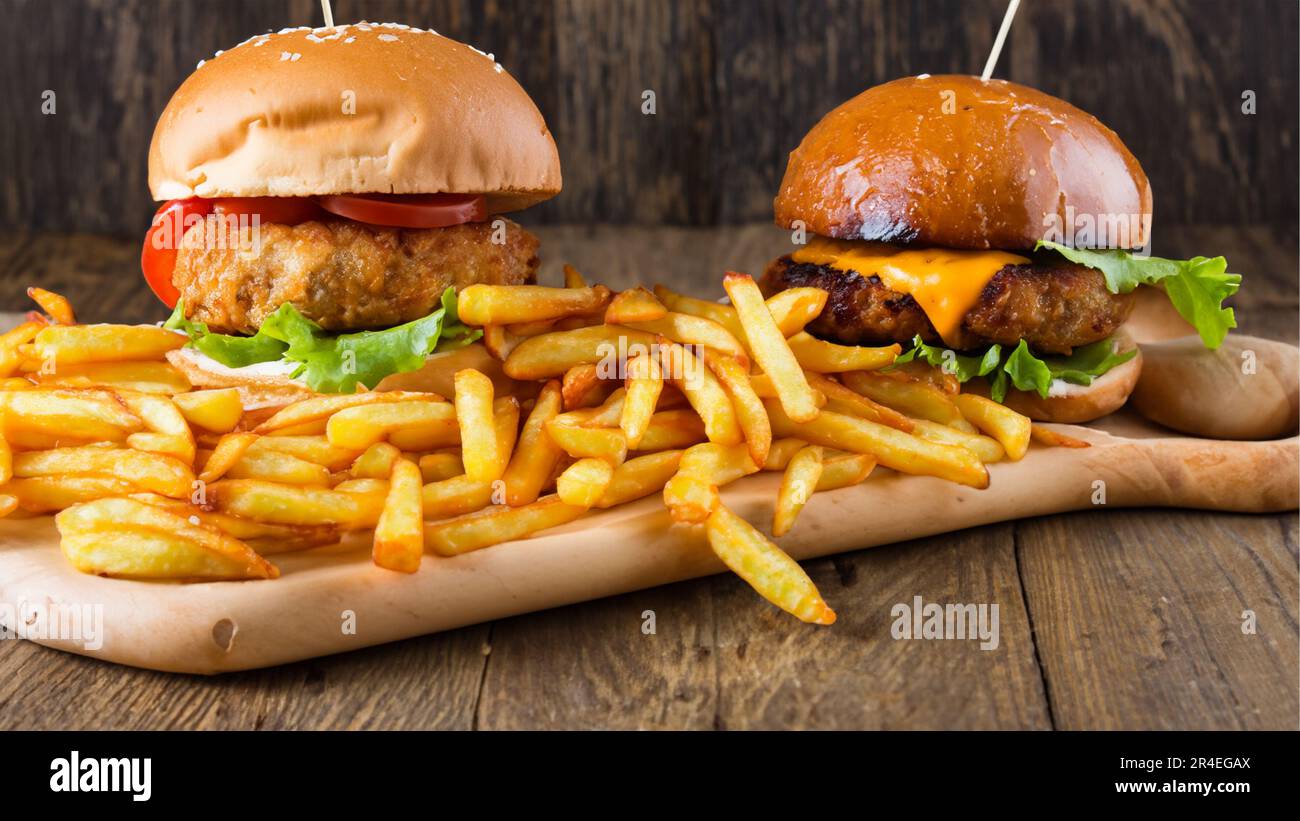 Leckerer Burger mit pommes Frites auf einem Holztisch Stockfoto