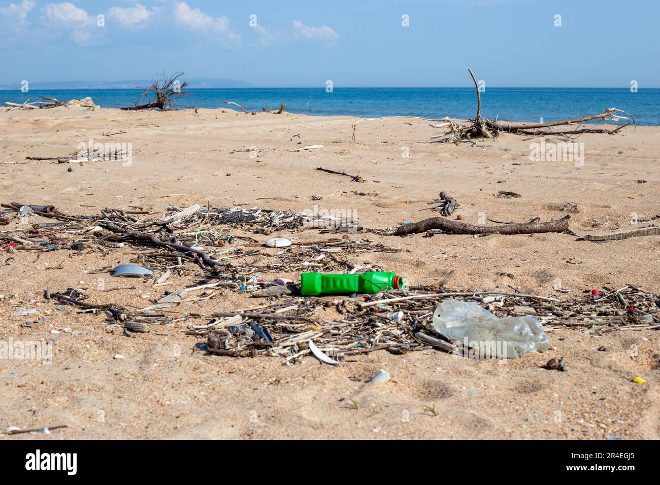 Müll am Strand. Plastikmüll wurde von einer Welle an einem Sandstrand transportiert. Ökologische Katastrophe. Stockfoto