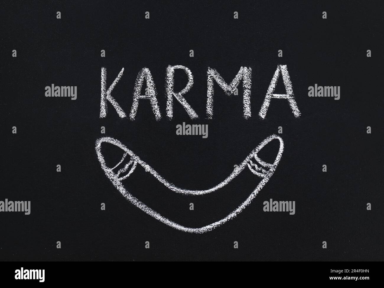 Gezeichneter Bumerang und das Wort Karma auf der Tafel Stockfoto