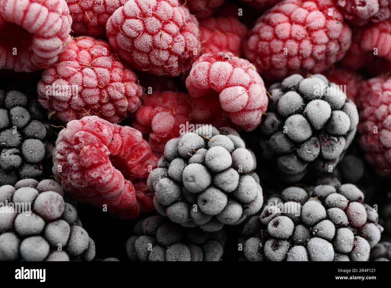 Leckere gefrorene Himbeeren und Brombeeren als Hintergrund, Draufsicht Stockfoto