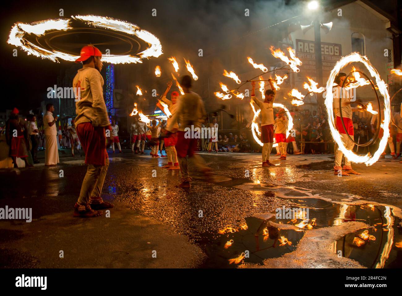 Feuerball-Tänzer führen entlang einer Straße während der buddhistischen Esala Perahera (große Prozession) in Kandy in Sri Lanka. Stockfoto