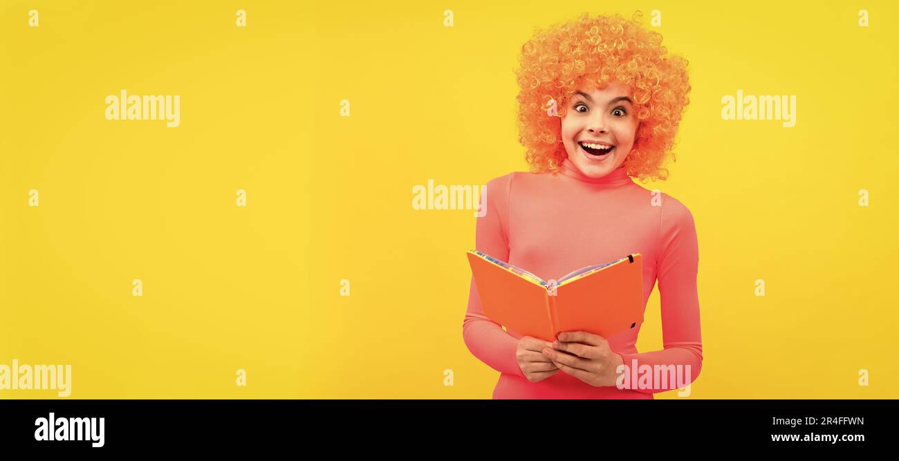 Glückliches Mädchen Kind mit orangen Haaren in rosa Poloneck Lächeln halten Schulbuch, Bildung. Lustige Teenager Kind auf der Party, Poster-Banner-Header mit Kopie Stockfoto