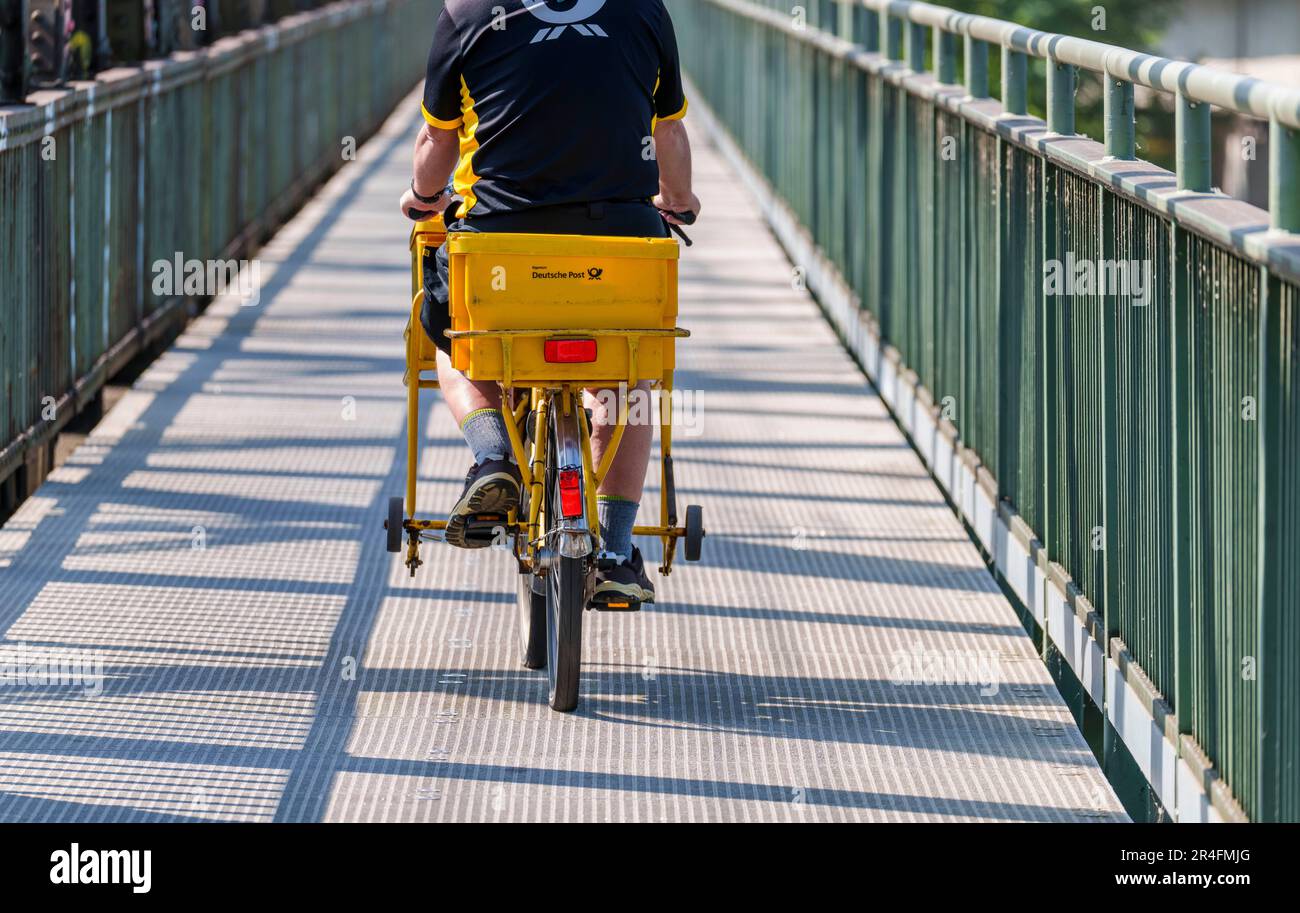 27. Mai 2023, Hessen, Frankfurt/Main: Ein Briefträger fährt sein Fahrrad über eine Brücke ohne Elektroantrieb. Foto: Andreas Arnold/dpa Stockfoto