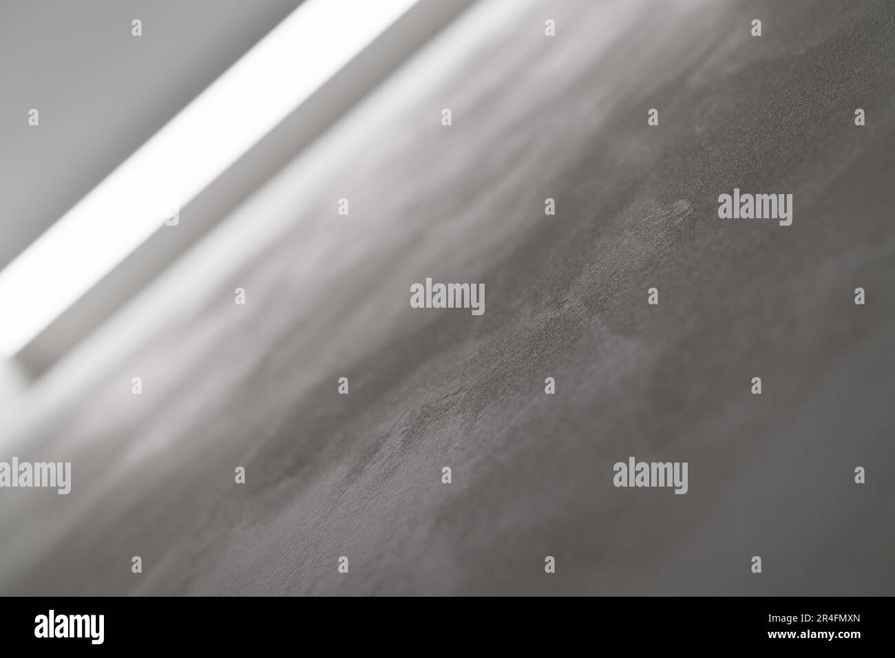 Abstraktes Foto einer weißen Wand mit Lichtreflexion von einer Lichtleiste, flacher Fokus Stockfoto