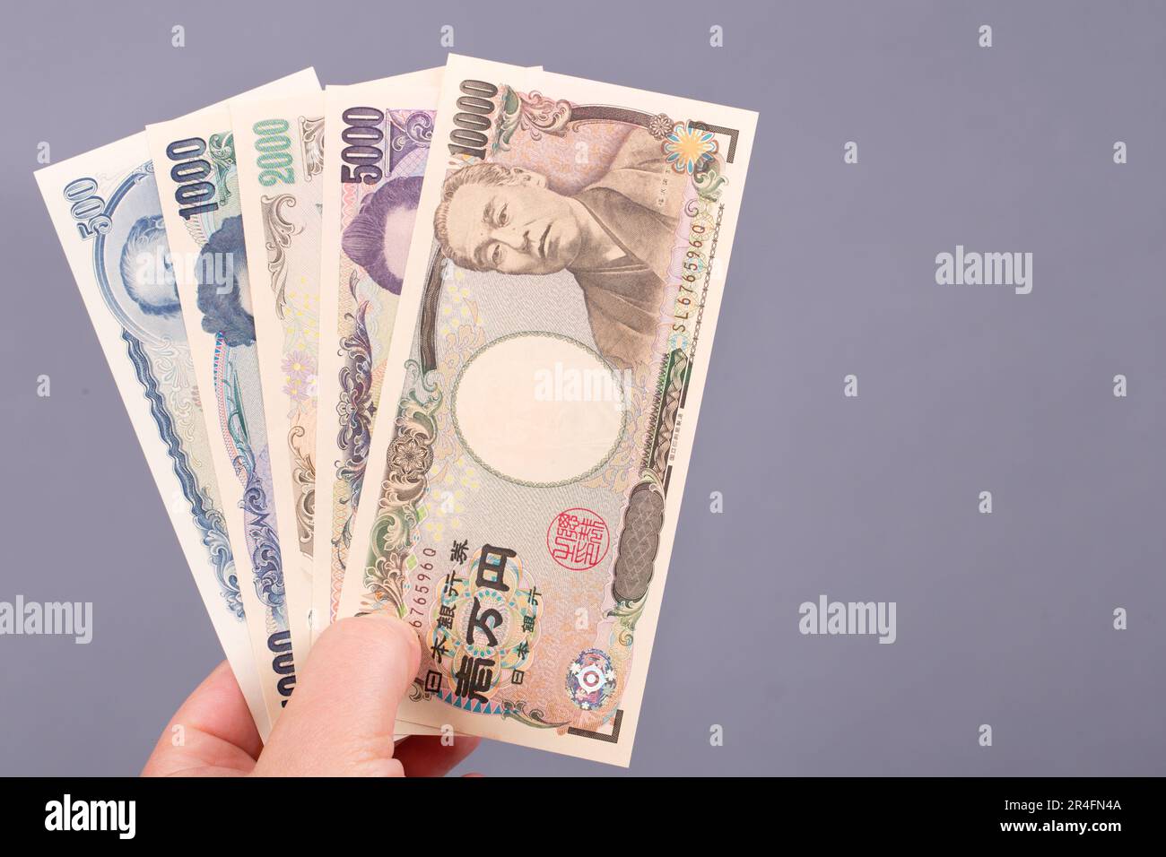Japanisches Geld - Yen in der Hand auf grauem Hintergrund. Stockfoto