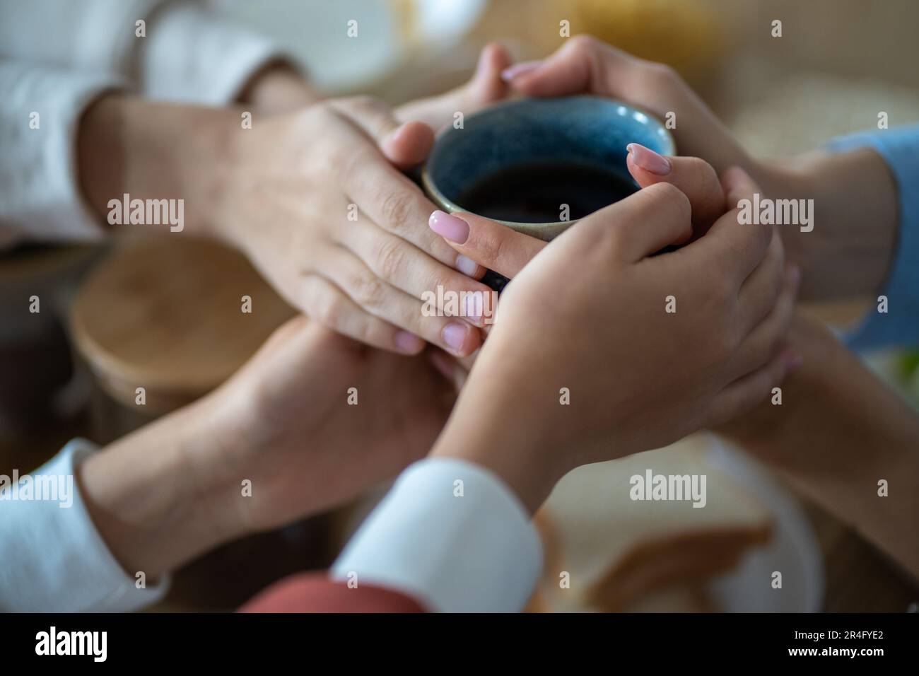 Familie hält eine Tasse Tee in den Händen, wärmt sich in einer kalten Wohnung Stockfoto