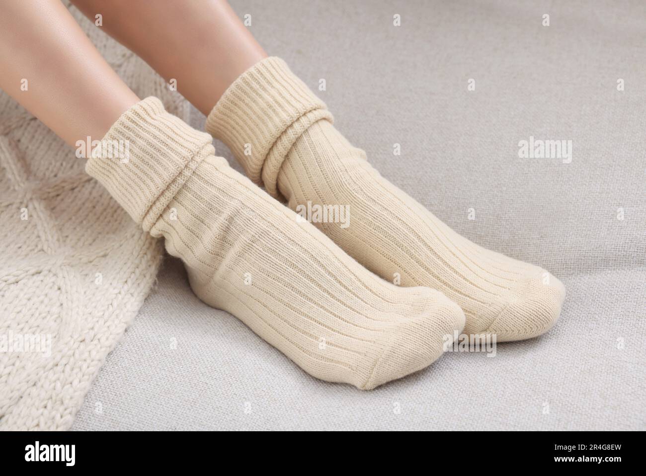 Eine Frau in warmen Socken auf dem Sofa zu Hause, Nahaufnahme Stockfoto