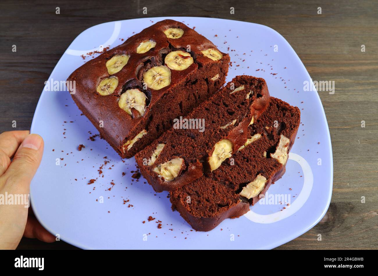 Frisch gebackener, köstlicher, hausgemachter Bananenkuchen mit dunkler Schokolade auf einem Holztisch Stockfoto