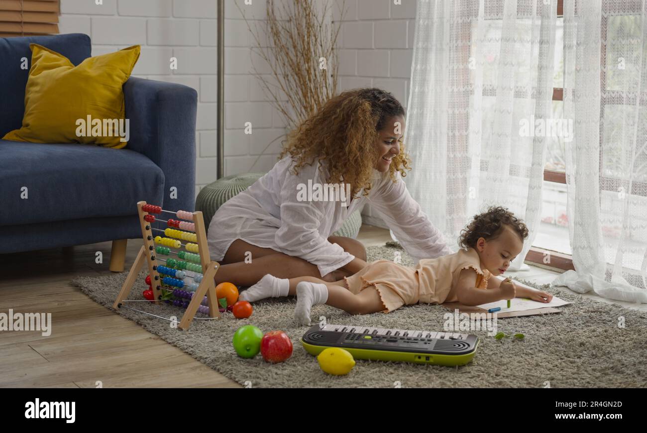 Mutter und Tochter spielen ein Spielzeug und haben Spaß im Wohnzimmer. Stockfoto