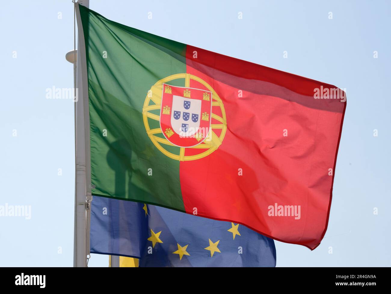 Portugiesische Staatsflagge und Flagge der Europäischen Union, die im Wind winken Stockfoto