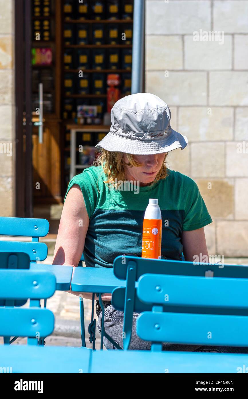 Frau mit Sonnenhut am Café-Tisch - Tours, Indre-et-Loire (37), Frankreich. Stockfoto
