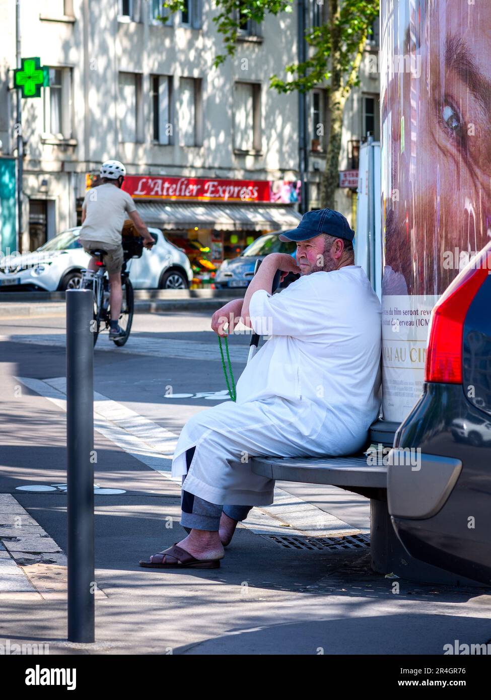 Aram Mann in weißer Kleidung sitzt auf der Bank im Stadtzentrum - Tours, Indre-et-Loire (37), Frankreich. Stockfoto