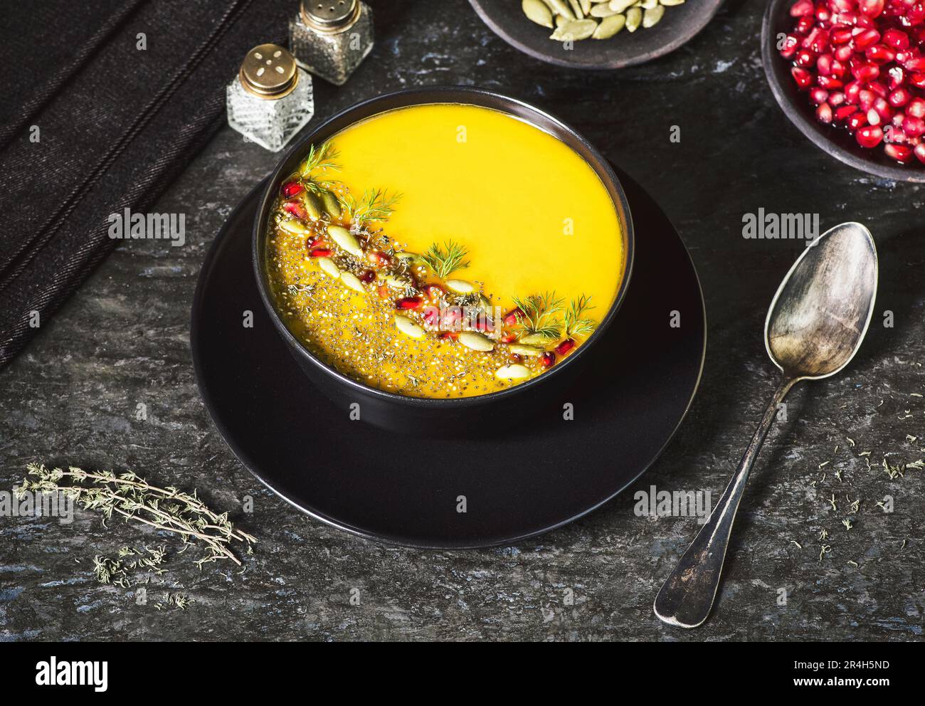 Kürbissuppe und Karottensuppe mit Granatapfel, Chiasamen, knusprigen Kürbiskernen, gehacktem Dill und gemahlenem schwarzen Pfeffer. Stockfoto