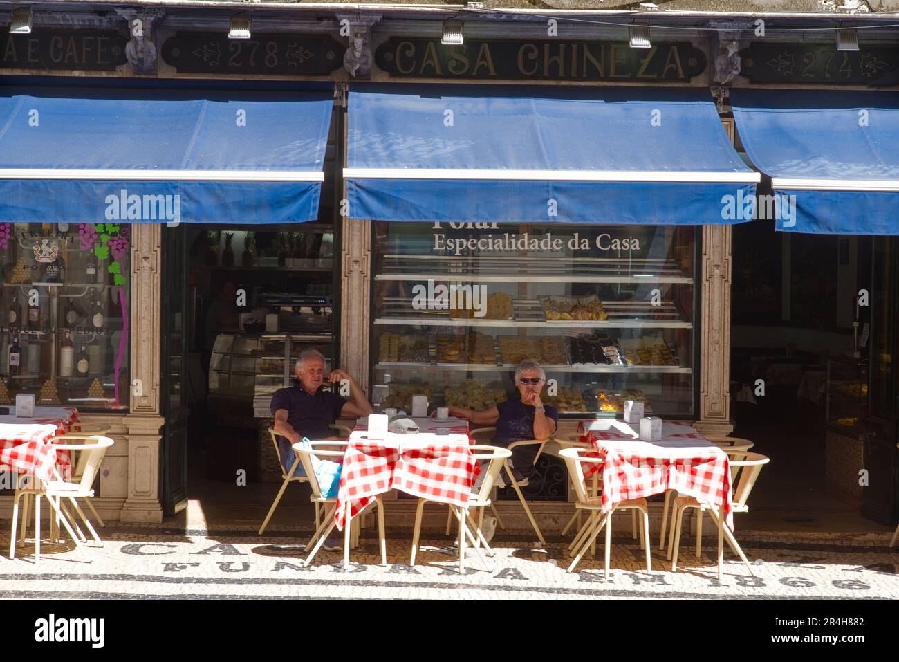 Ein Paar sitzt im Schatten vor dem Casa chineza Café im Zentrum von Lissabon Stockfoto