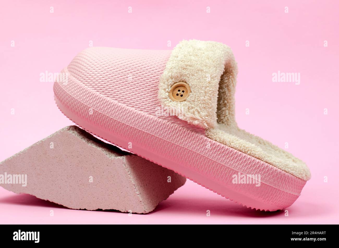 Warme Hausschuhe mit Fell auf pinkfarbenem Hintergrund. Hausschuhe für das Zimmer Stockfoto
