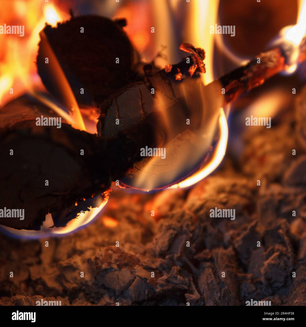 Ein helles Feuer mit hoher Temperatur aus natürlichem Brennholz und Ästen brennt im Ofen und heizt das Haus in der kalten Jahreszeit, mit Schönheitshorizont. Quadrat Stockfoto