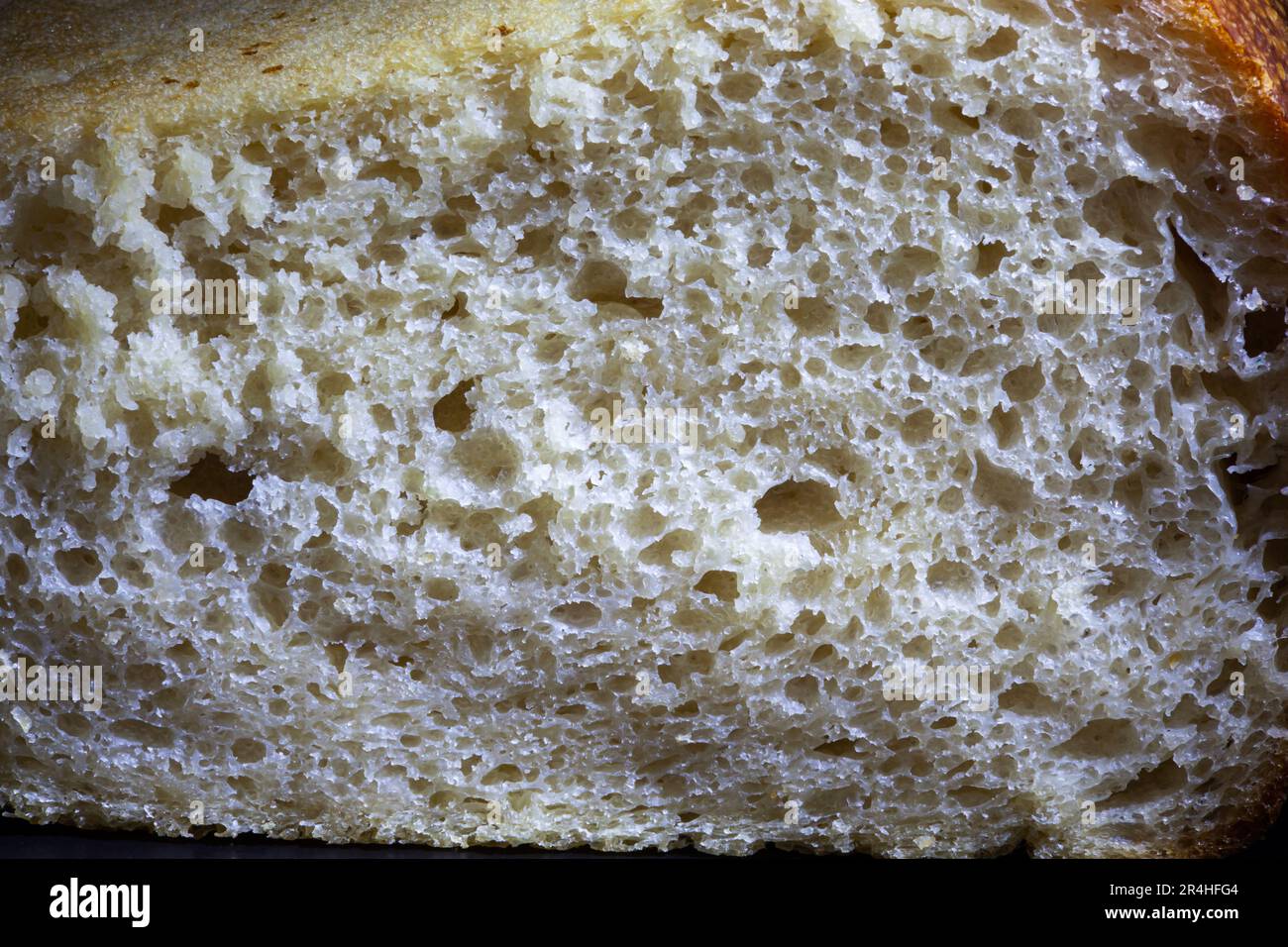 Eine Scheibe Roggenbrot mit knuspriger Kruste und Textur im Loch. Frisches, hausgemachtes Sauerteigbrot. Foto in hoher Qualität Stockfoto
