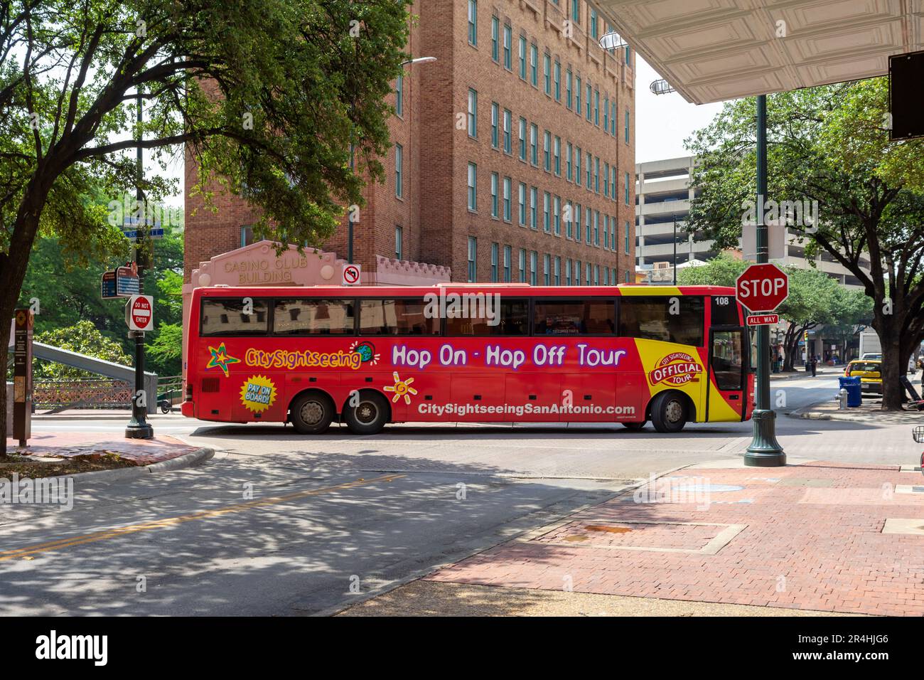 San Antonio, Texas, USA – 8. Mai 2023: Ein roter Sightseeing-Bus fährt eine enge Kurve auf einer schmalen Innenstadtstraße in San Antonio, Texas. Stockfoto