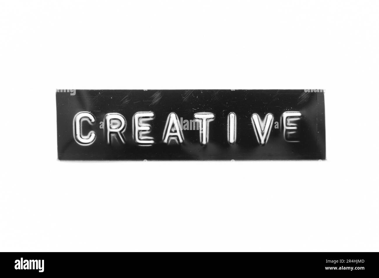 Schwarzes Banner mit geprägtem Buchstaben und Wort Creative auf weißem Papierhintergrund Stockfoto