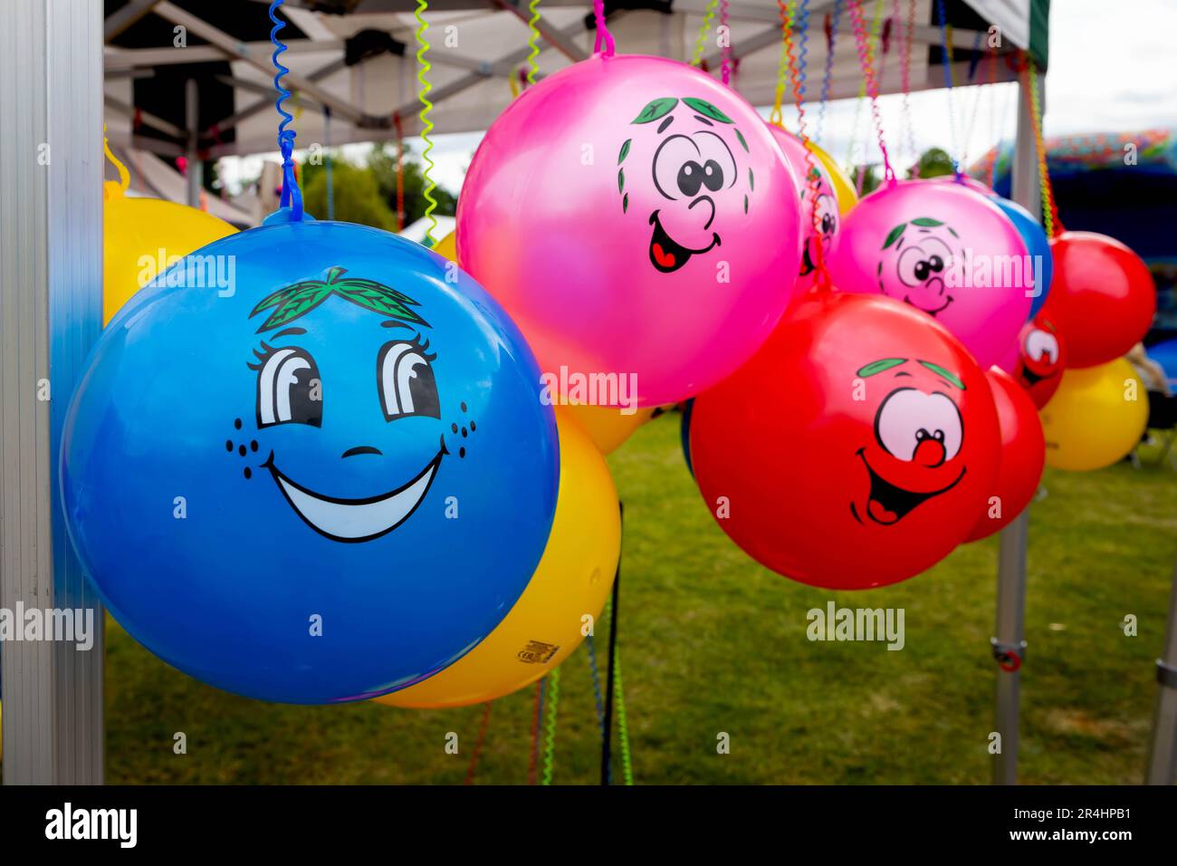 Eine Reihe von Punchbällen mit fröhlichen Gesichtern unter einem Pavillon auf einer Party Stockfoto