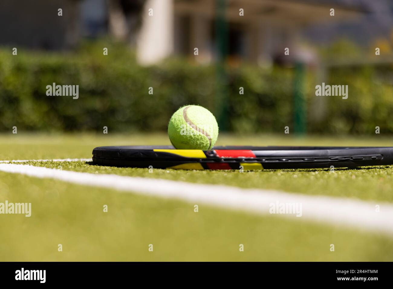 Nahaufnahme von Tennisschläger und Ball durch weiße Markierung auf dem Rasenfeld auf dem Tennisplatz Stockfoto