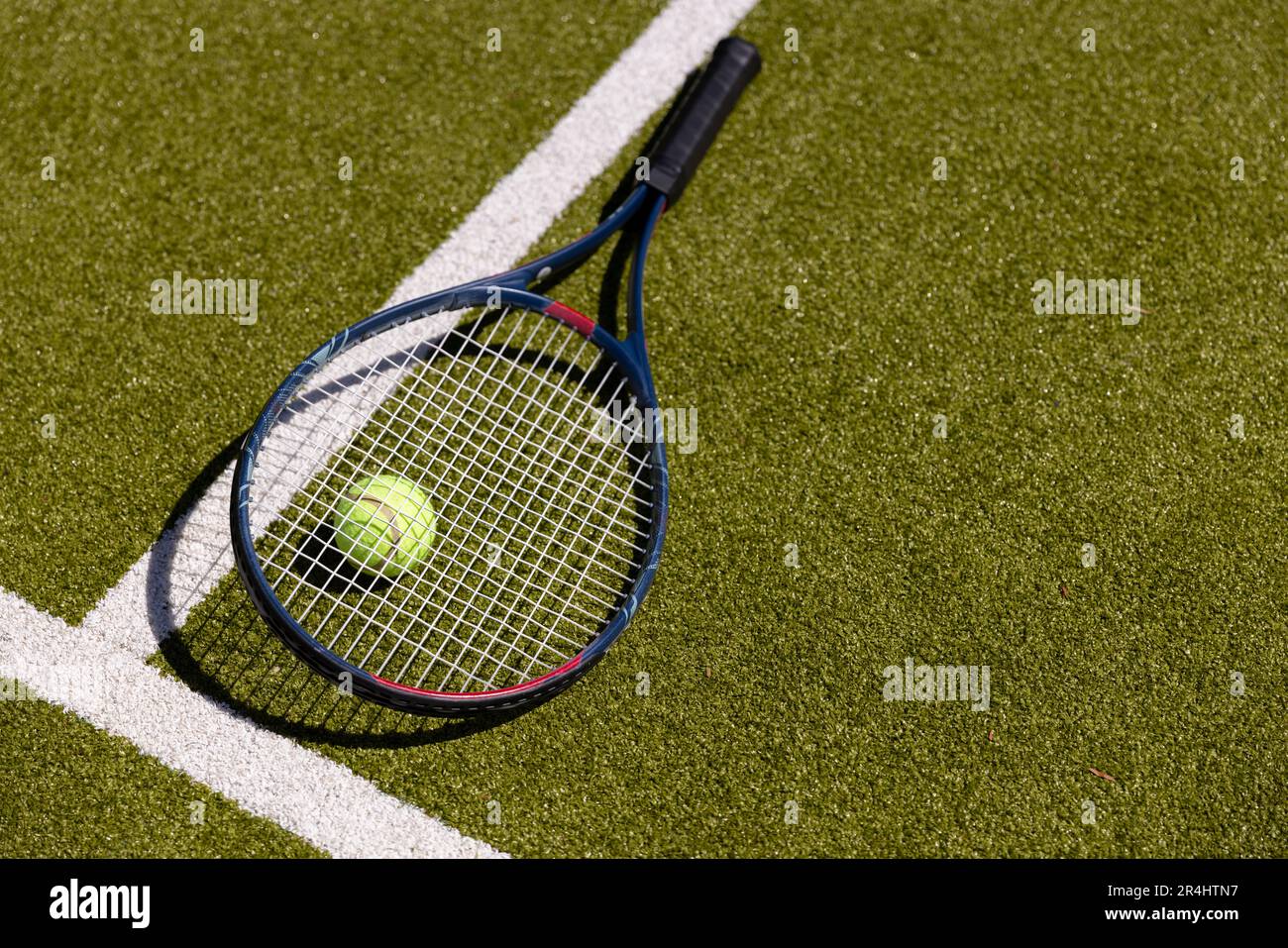 Blick auf Tennisschläger und -Ball aus einem hohen Winkel durch Markierung auf dem grasbedeckten Feld auf dem Tennisplatz Stockfoto