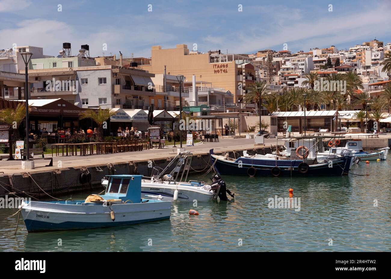Östliches Kreta, Griechenland, Europa. 2023, Uferpromenade des Siteia Hafens im östlichen Kreta mit seinen kleinen Booten, Hotels und Restaurants am Meer Stockfoto