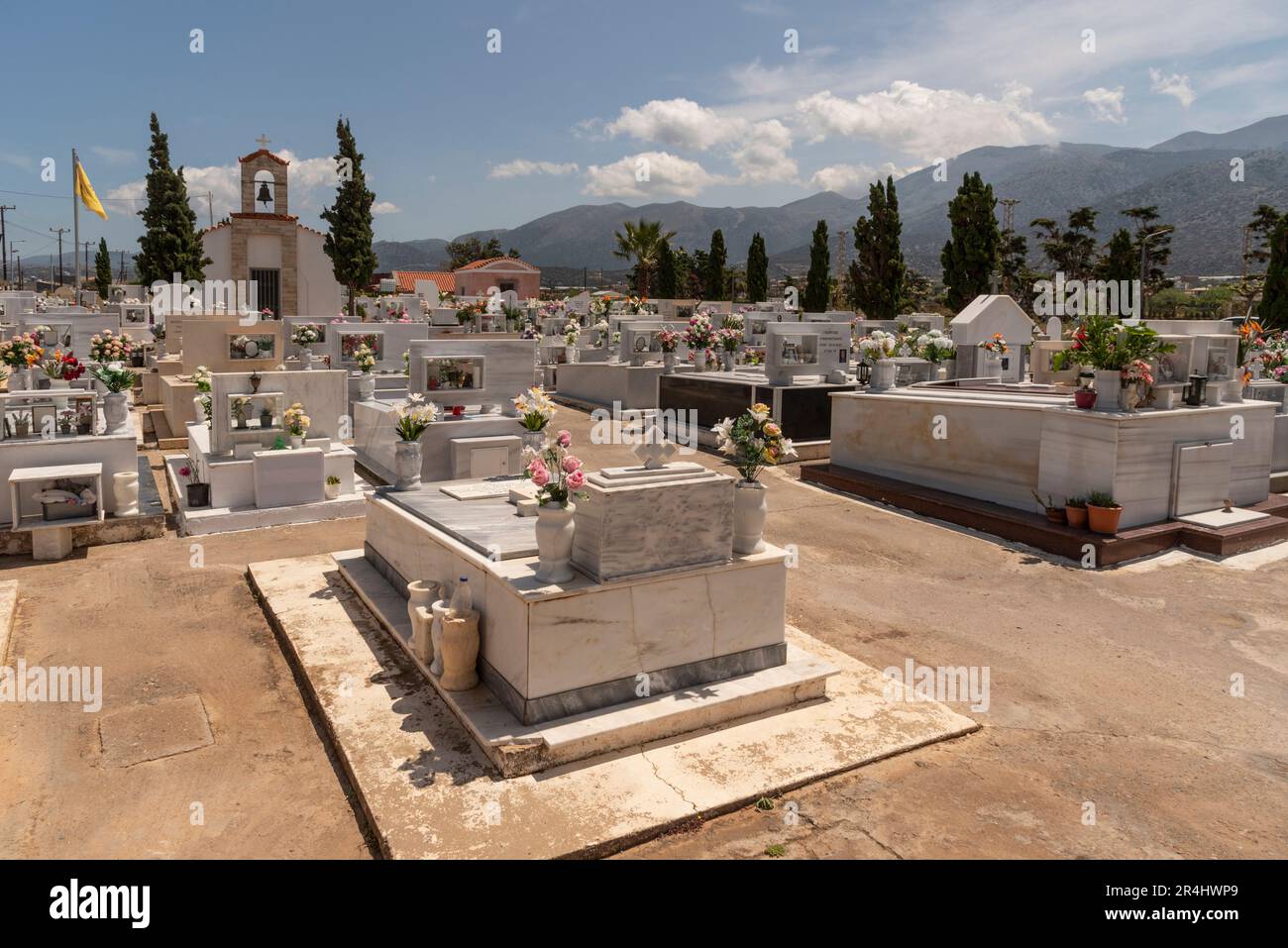 Malia, Ostkreta, Griechenland, Europa. 2023. Ein Uberblick über den Malia-Friedhof mit seinen Grabsteinen und dekorativen Blumen. Stockfoto