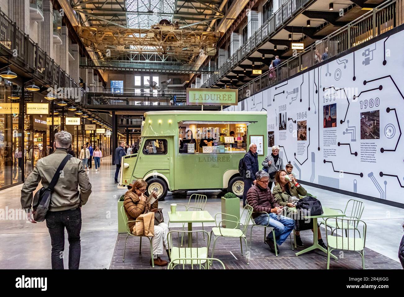 Leute, die Kaffee trinken in einem Catering-Van mit der Marke Maison Ladurée im Erdgeschoss der Turbine Halle A am Battersea Power Station, London, SW11 Stockfoto