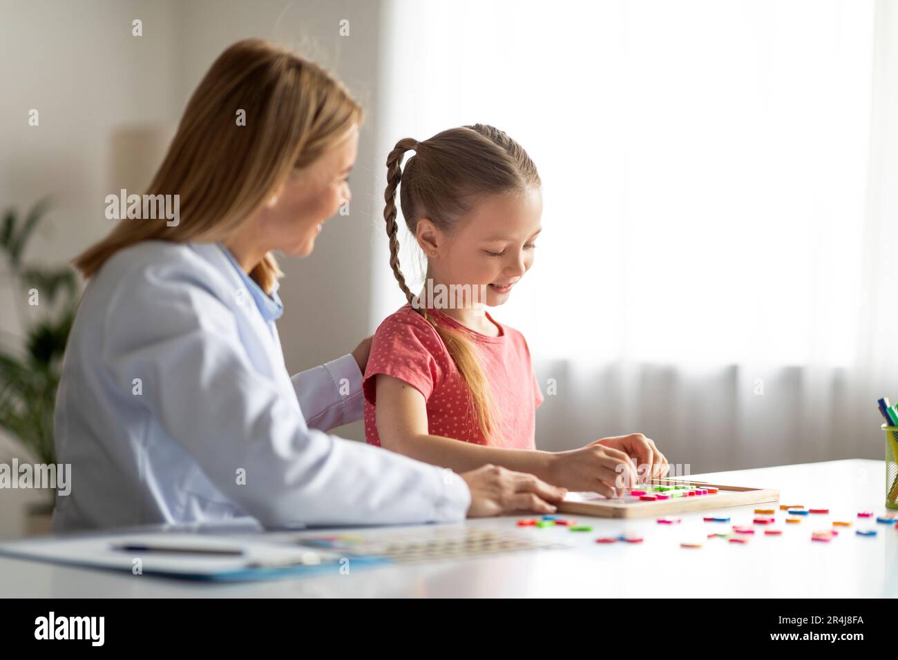 Vokabelbildung. Kleines Mädchen, Das Während Der Therapiesitzung Wörter Mit Bunten Buchstaben Macht Stockfoto