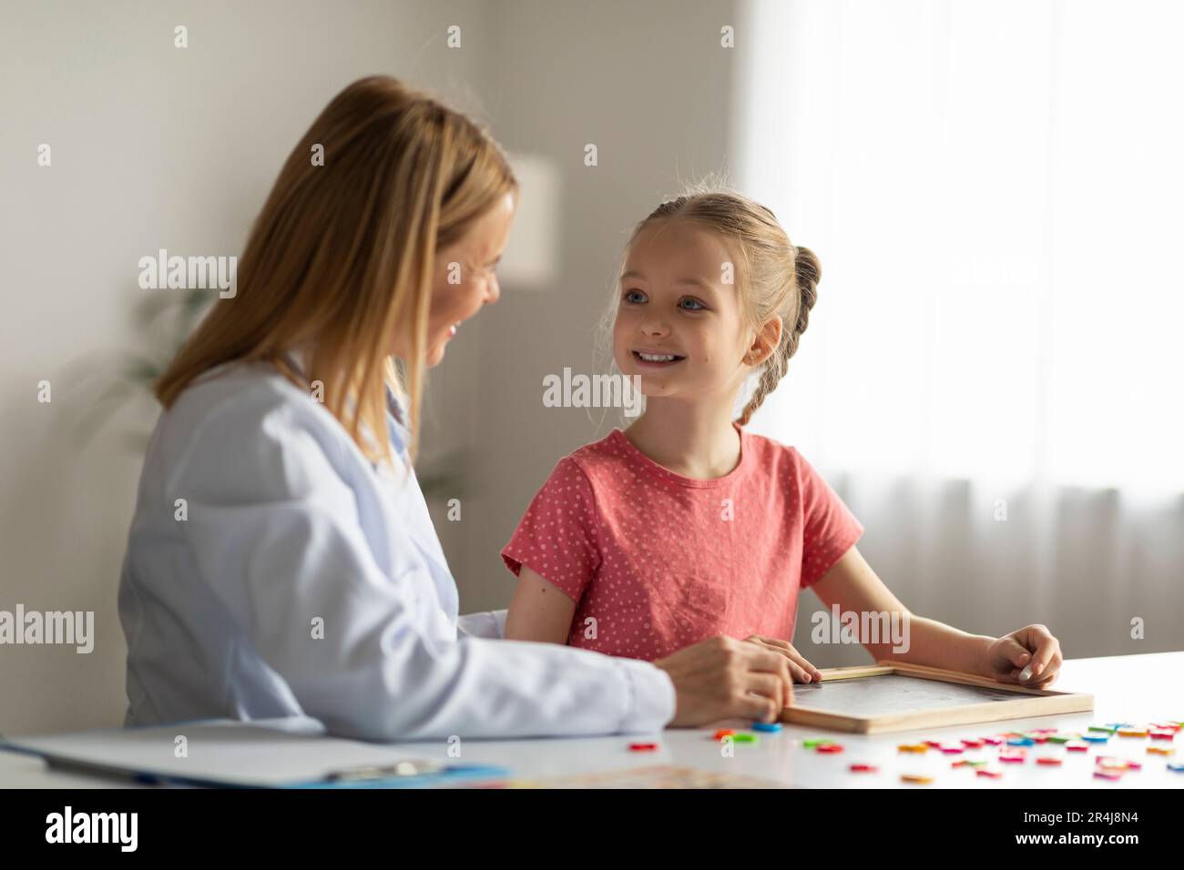 Süßes Kleines Mädchen, Das Die Therapeutin Während Des Sitzungstreffens Im Büro Ansieht Stockfoto