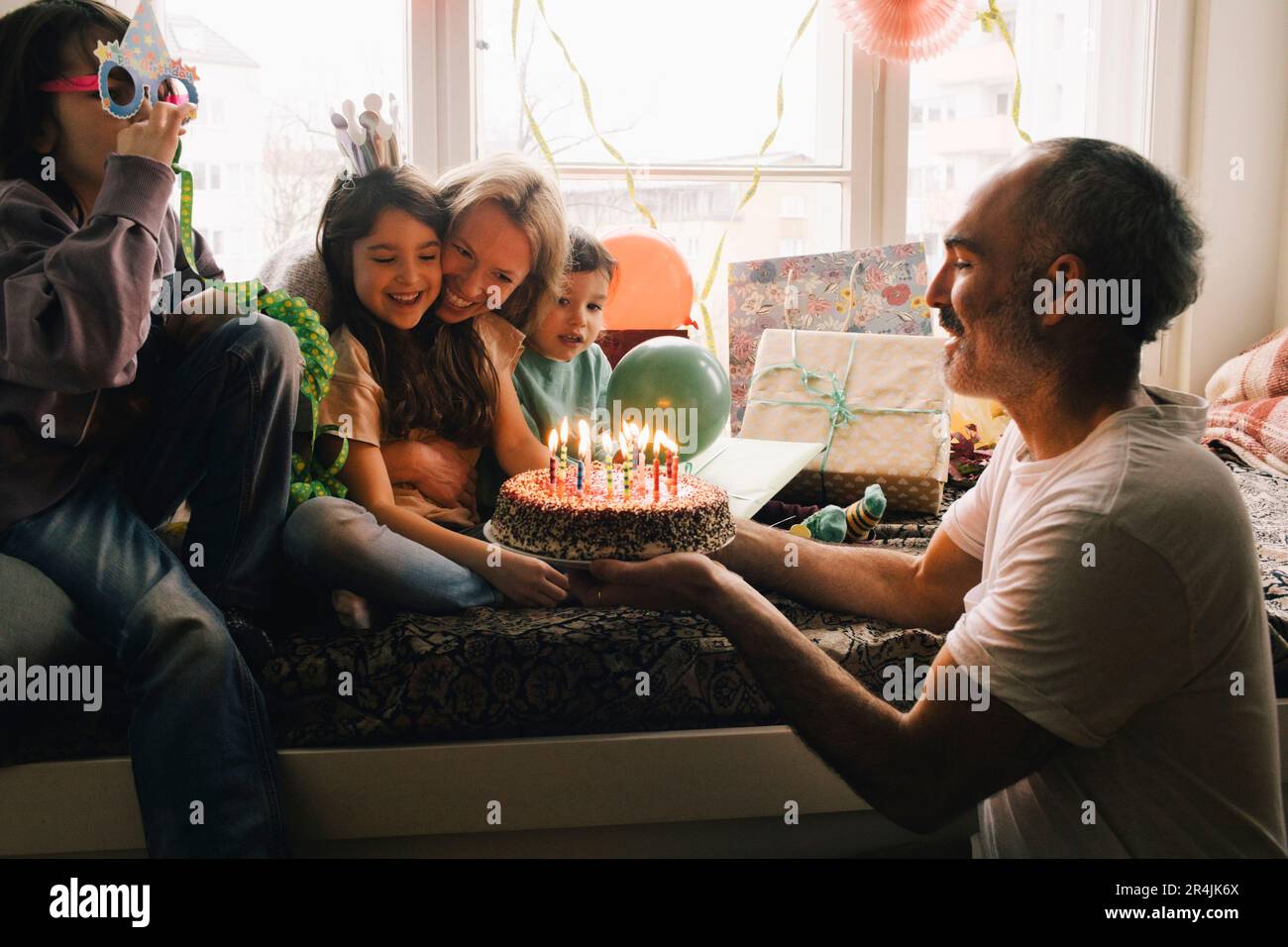 Glückliche Familie feiert Geburtstag mit Kuchen zu Hause Stockfoto