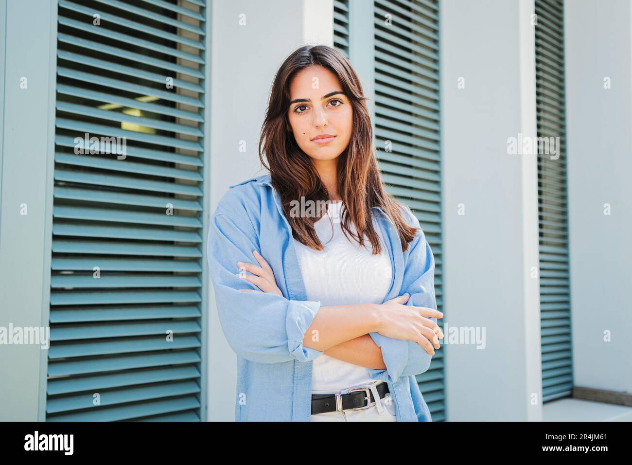 Kaukasische, seriöse, junge Studentin mit verschränkten Armen, die nachdenklich vor der Kamera in lässiger Kleidung im Freien steht. Nahaufnahme eines nachdenklichen Teenagers mit selbstbewusster Gesichtsausdruck-Pose. Hochwertiges Foto Stockfoto