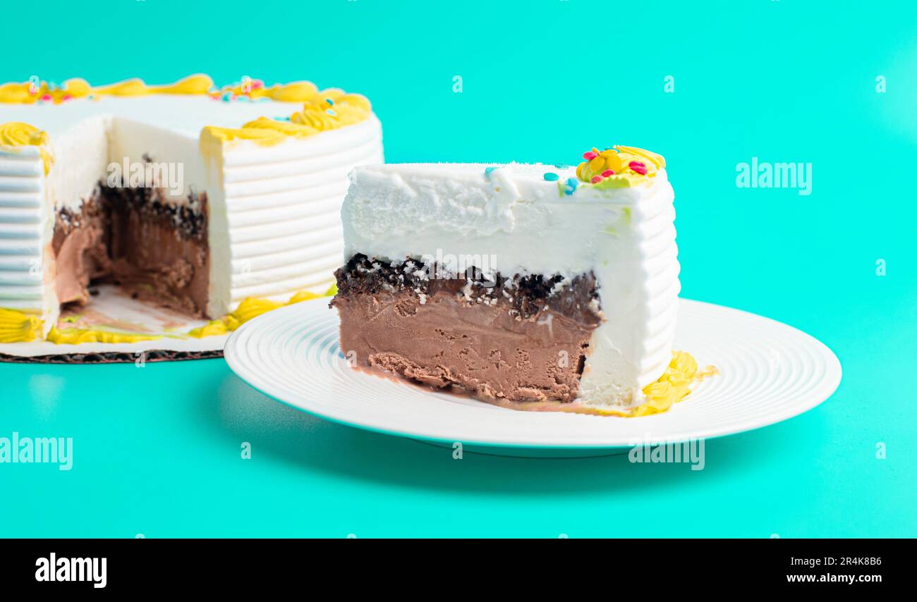 Ein Stück Vanille- und Schokoladeneiskuchen auf blauem Hintergrund Stockfoto