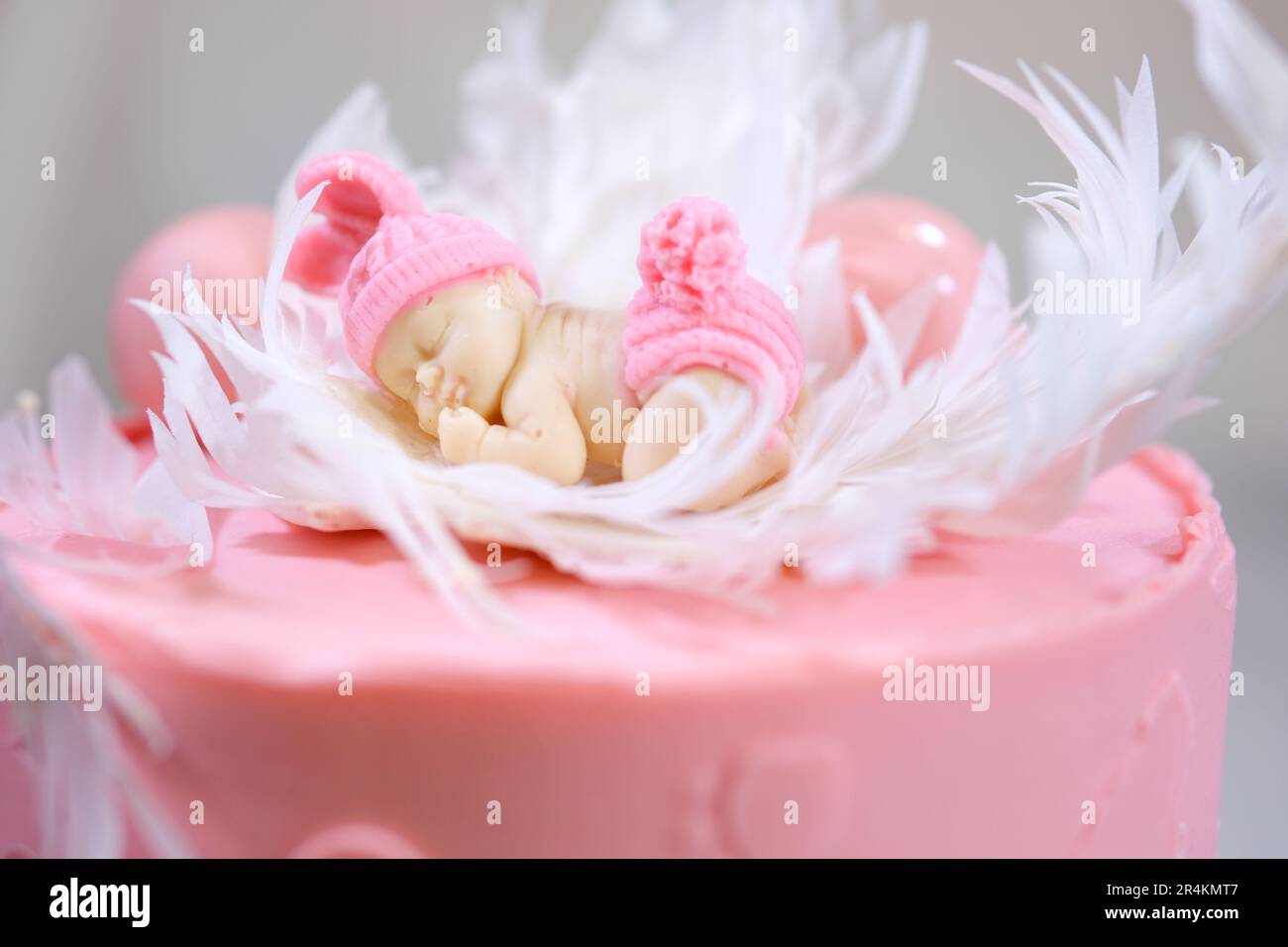 Dekoration eines Kuchens für eine Familie Taufe rosa Kuchen mit Fußabdrücken eines kleinen Kindes auf Engelsflügeln und Baby in rosa Windel ein Mädchen, wie man das Geschlecht des Kindes mithilfe eines Kuchens herausfinden kann Stockfoto