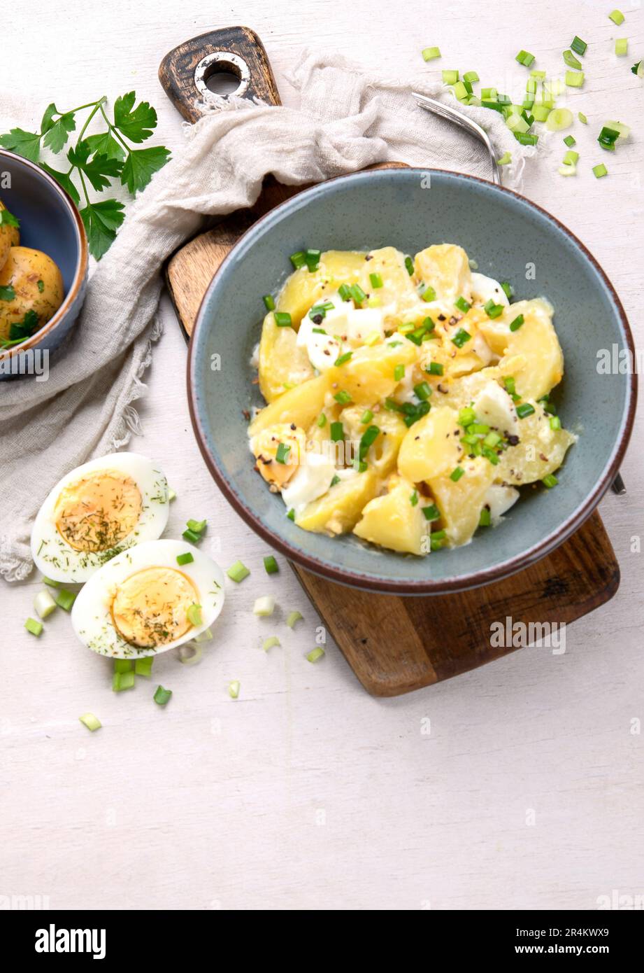 Salat aus Kartoffeln, Eiern, grünen Zwiebeln und Mayonnaise auf einem Teller auf weißem Hintergrund, Draufsicht. Speicherplatz kopieren. Stockfoto