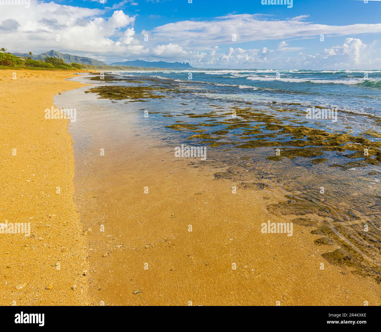 Exponiertes Korallenriff mit schlafendem Riesenberg in der Ferne, Nukolii Beach, Kauai, Hawaii, USA Stockfoto